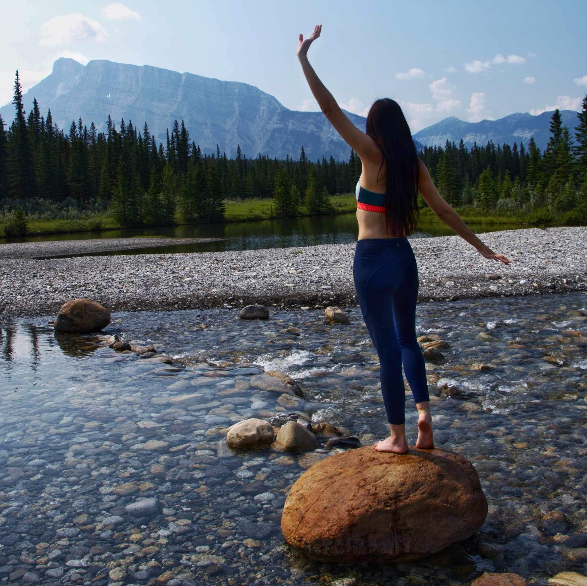 Layla Messner balancing on a rock by a mountain stream in Banff National Park