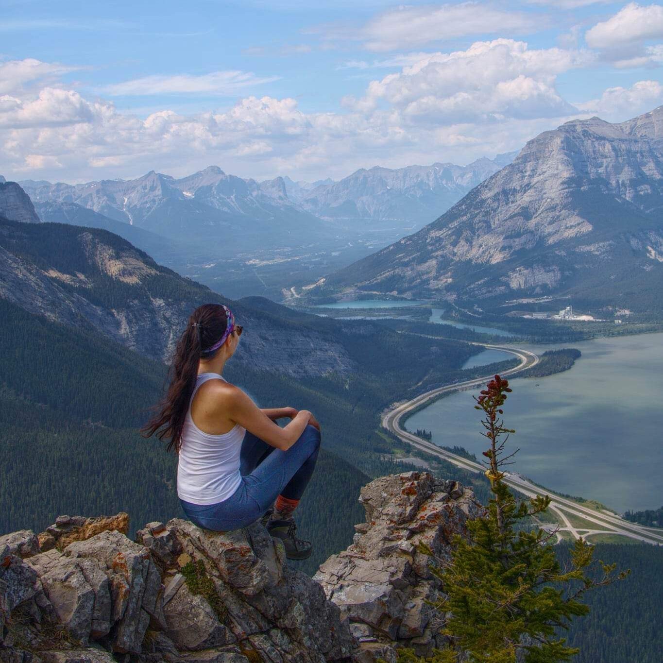 Layla Messner sitting on a mountain, overlooking the bow valley in Canmore Kananaskis. Photo by Kelly's Perspective.