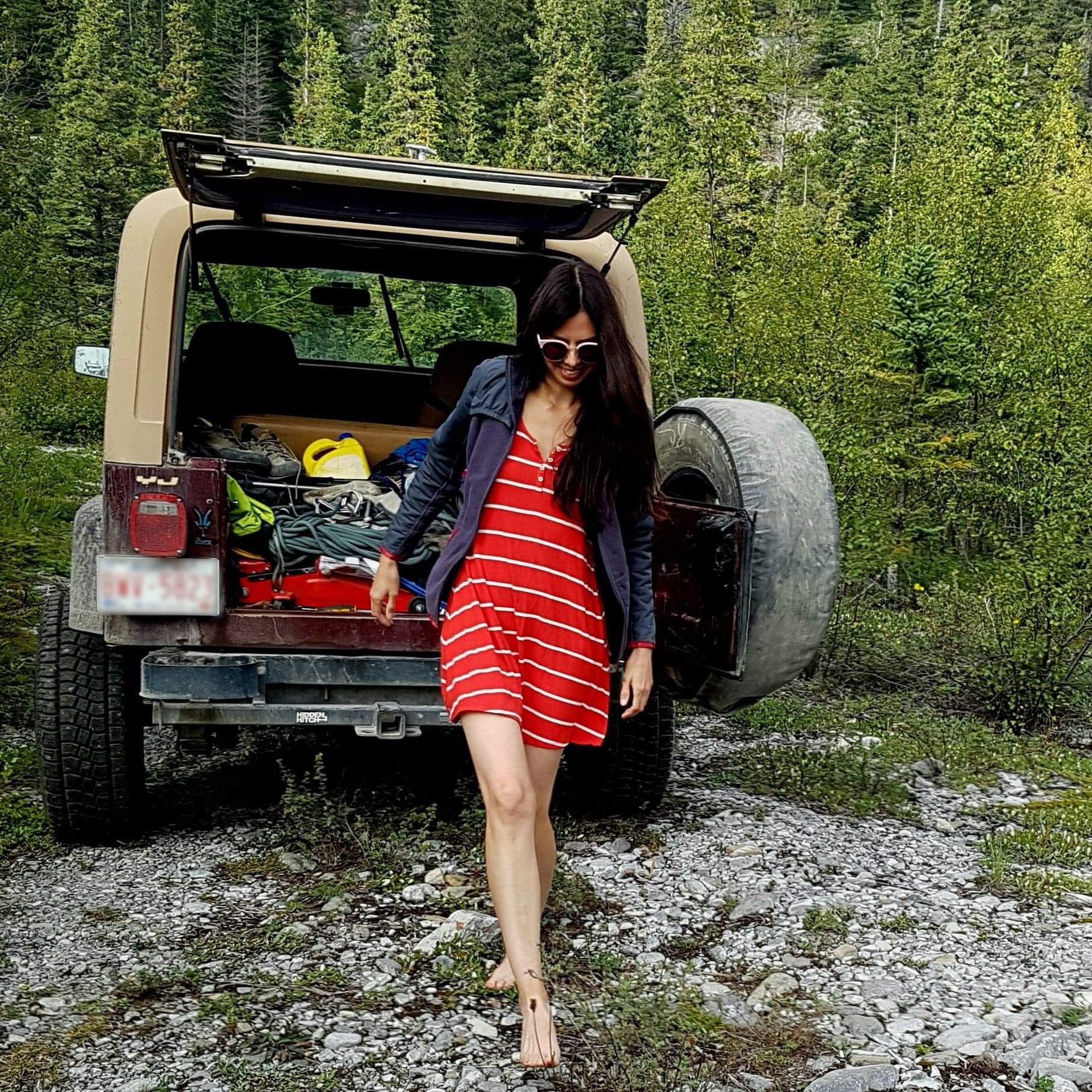 Layla Messner, The Instinctual Woman, walking barefoot behind a vintage Jeep YJ